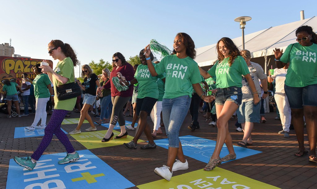 Nurses wearing green shirts and dancing