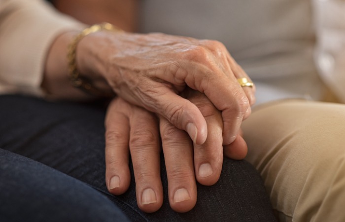 couple holding hands on their laps