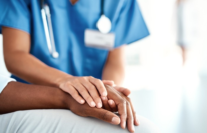 nurse holding patient's hand