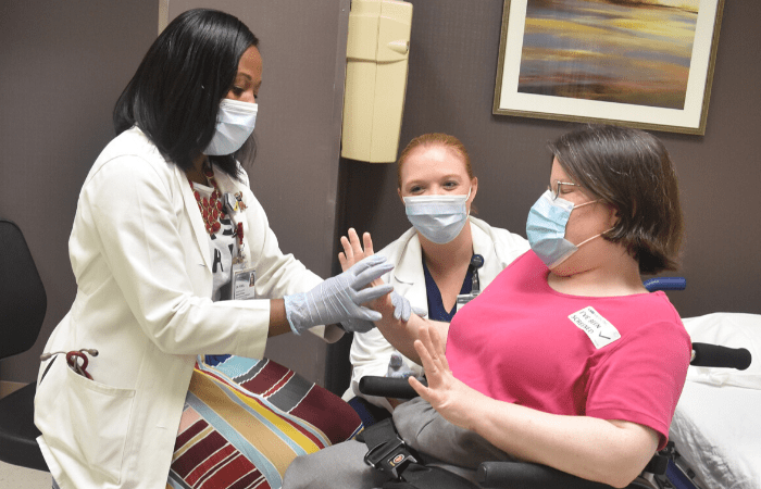 Doctor and nurse assisting patient in wheelchair