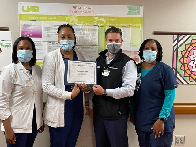 Group photo of medical professionals holding up a certificate