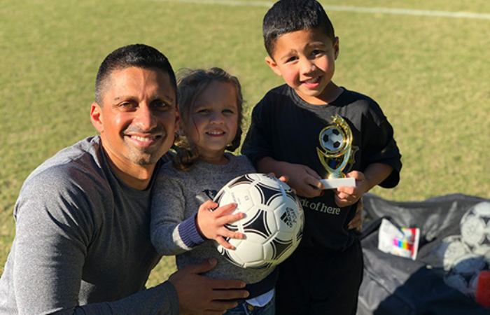 Irfan Asif, M.D., chair of the University of Alabama at Birmingham Department of Family and Community Medicine and kids with soccer trophies.