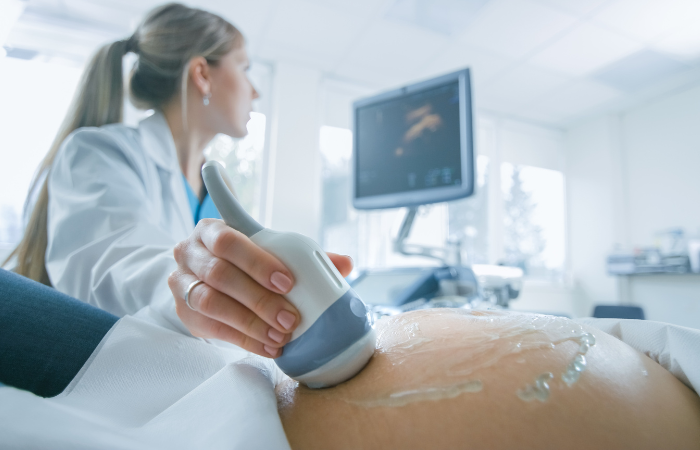 OBGYN female doctor conducting an ultrasound on a pregnant patient