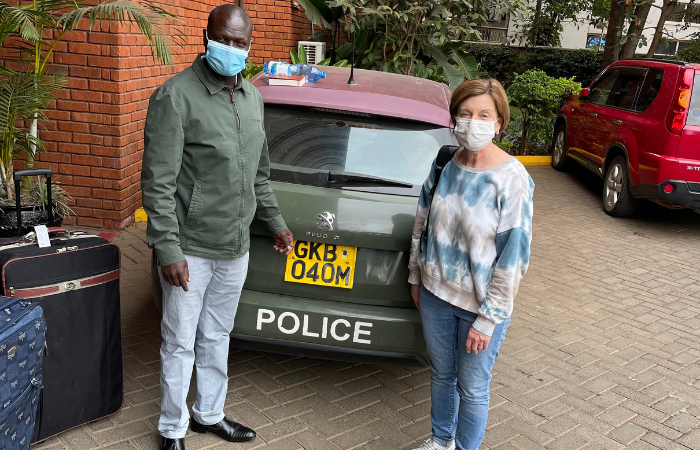 Coworkers posing together in front of a police vehicle