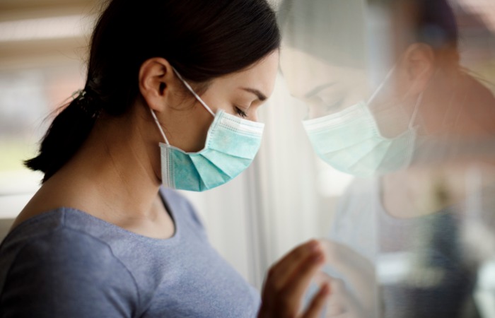 Female patient wearing mask, closing eyes and looking downward