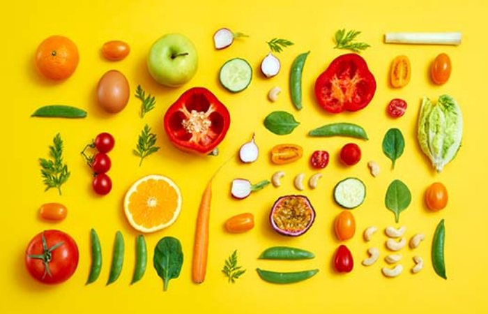 An assortment of fruits and vegetables, both whole and cut into pieces