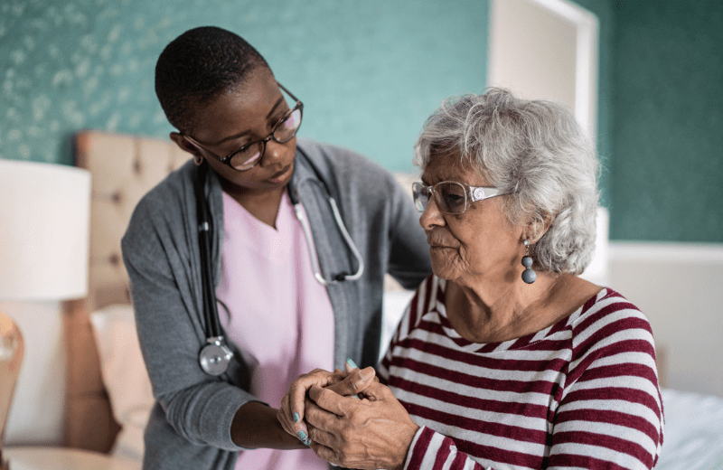 African American nurse assisting Parkinson's patient