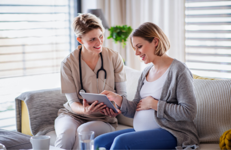 Female nurse assisting pregnant female patient