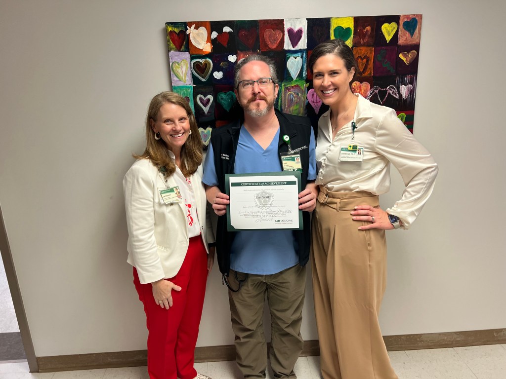 Two females handing award to male UAB Medicine employee