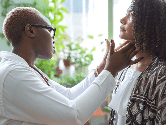 African American female physician examining an African American female patient