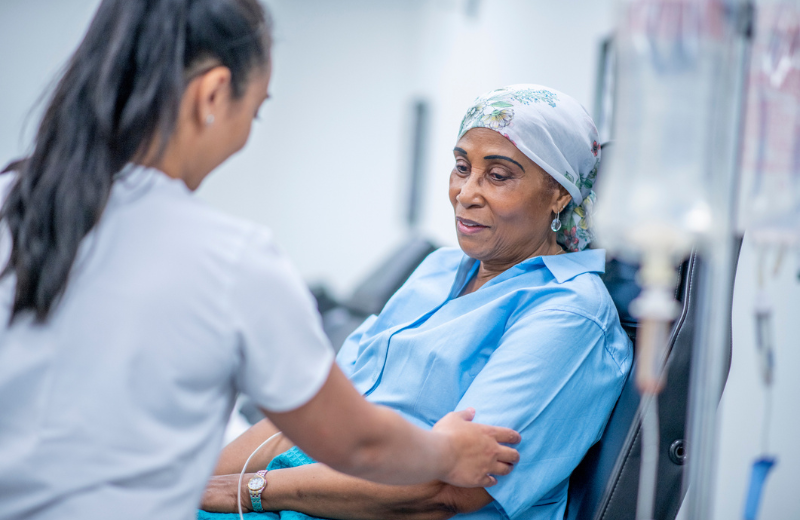 Nurse tending to a female African American cancer patient