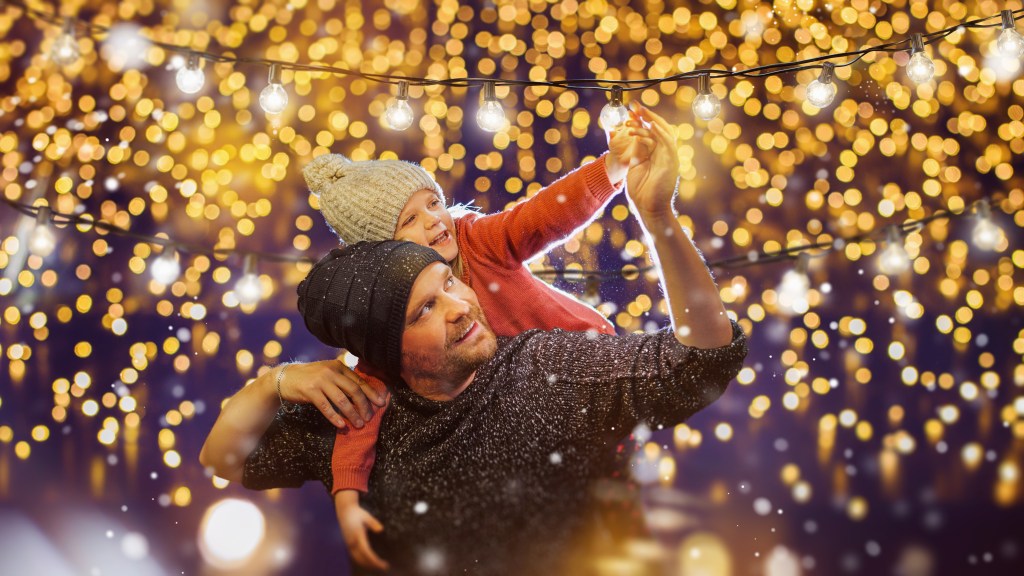 father and daughter decorate outside for holiday family party